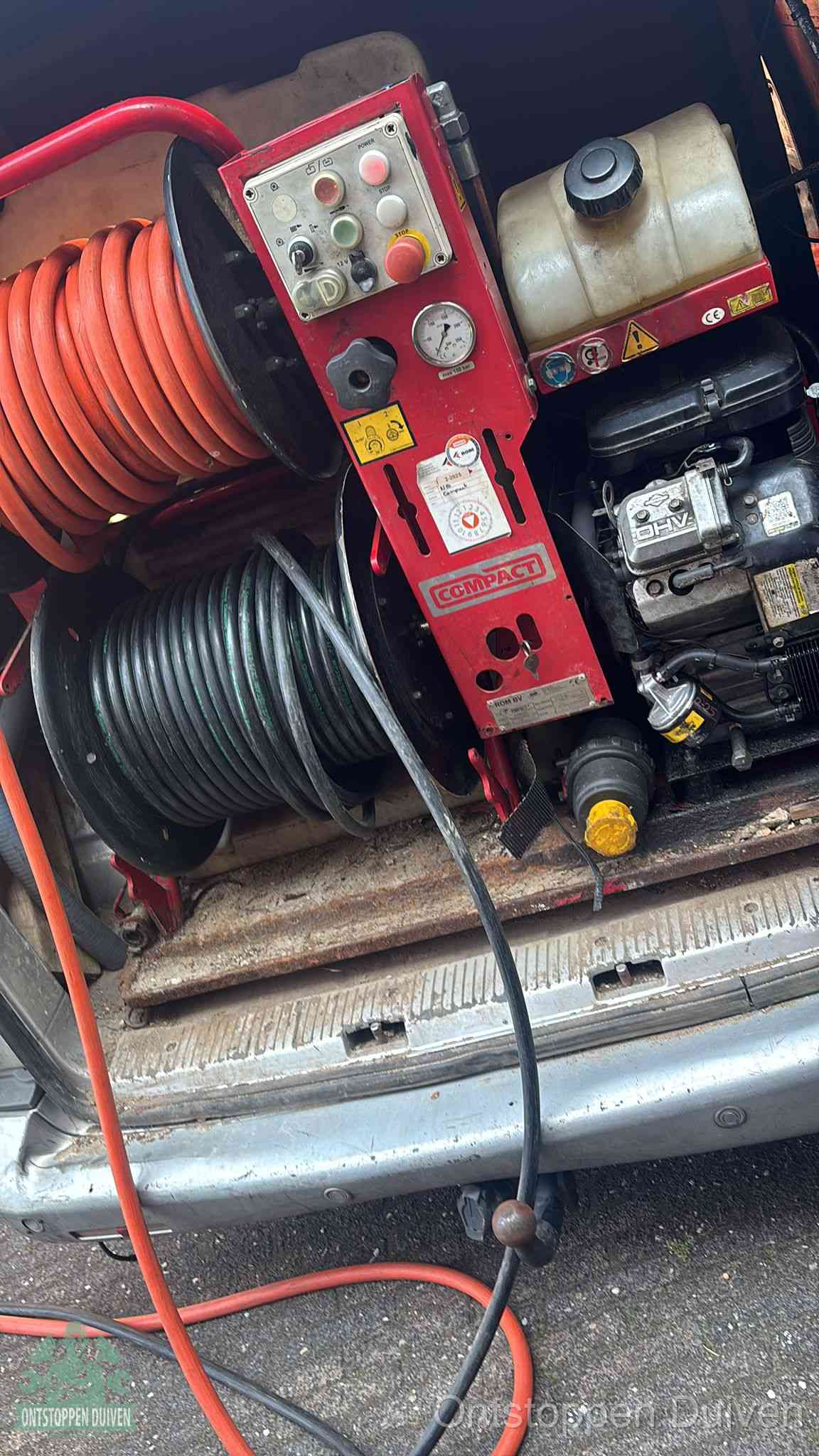 Een rood hogedruk-rioolreinigingstoestel in de laadbak van de bedrijfsbus, apparatuur voor een hardnekkige afvoerverstopping in Duiven