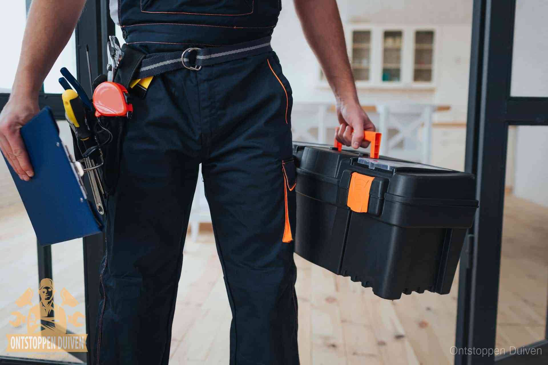 Een monteur met gereedschapsriem en klembord in een keuken, klaar om een transparante prijs voor het gootsteen ontstoppen in Duiven te geven Een monteur met gereedschapsriem en klembord in een keuken, klaar om een transparante prijs voor het gootsteen ontstoppen in Duiven te geven