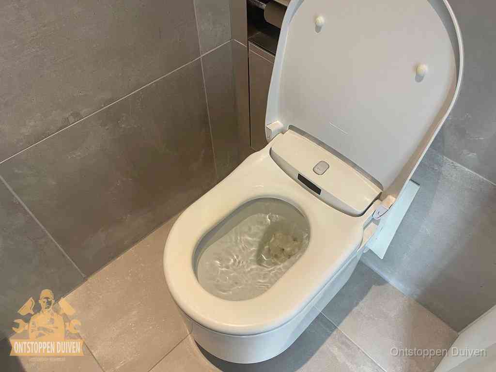 Een toiletpot vol troebel water met drijvend papier en restanten, de meest voorkomende oorzaak van een verstopte wc in Duiven