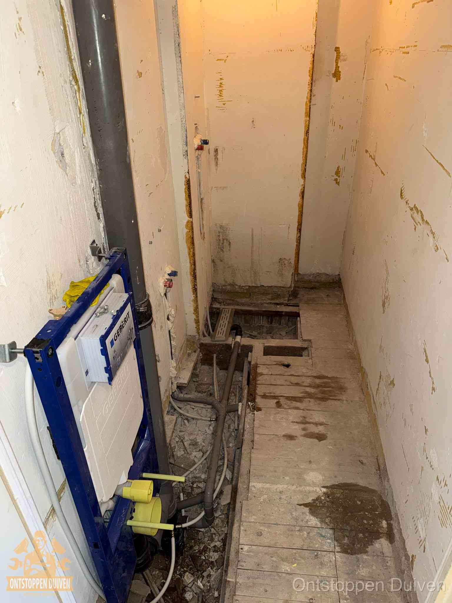 Een opgebroken toiletruimte tijdens renovatie met een Geberit inbouwreservoir en blootliggende oude afvoerleidingen, typisch voor oudere woningen in Duiven